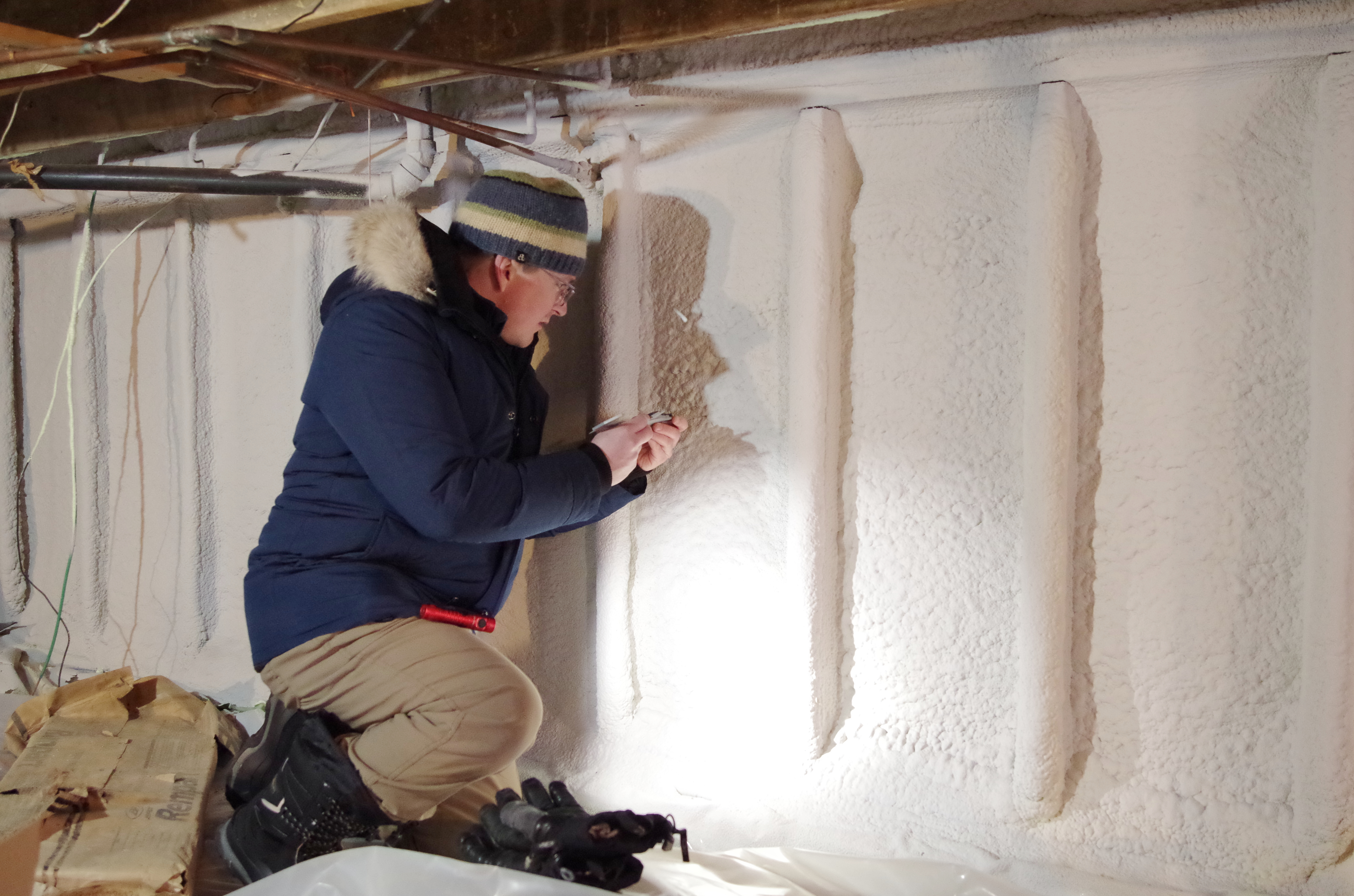 CLEAResult staff Aaron Taylor checks the depth of sprayfoam insulation